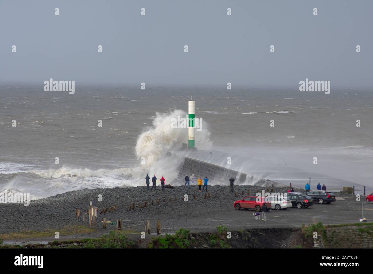 Die Sturmwinde, die über 60mph Uhr stürmen, und die morgendliche Flut verbinden sich und bringen riesige Wellen über die Irische See, um Aberystwyth zu schlagen. Stockfoto