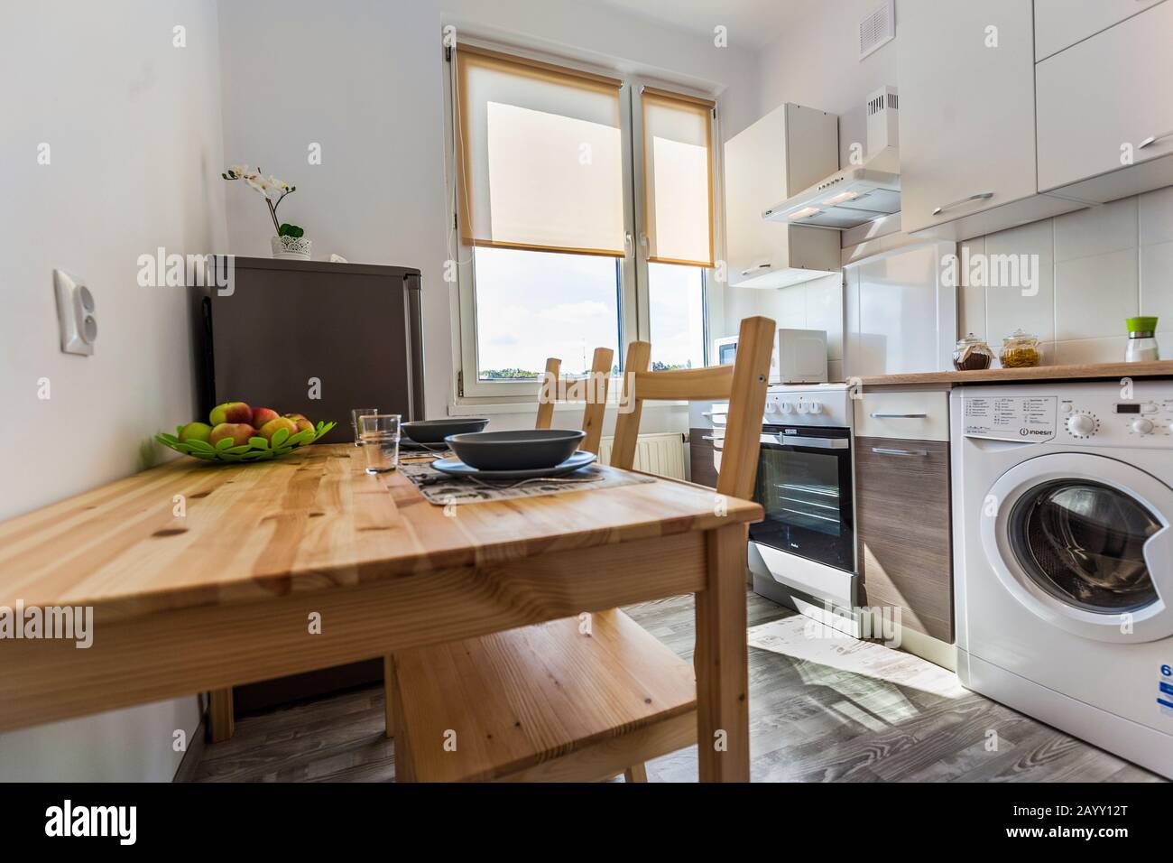 Echte helle Küche mit Tisch, zwei Stühlen, Waschmaschine Stockfotografie -  Alamy