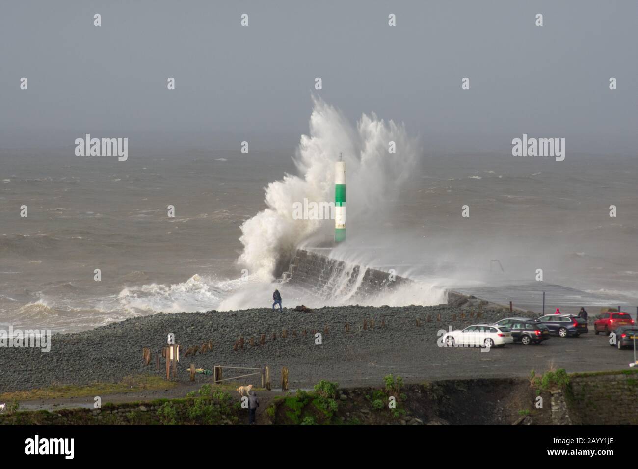 Die Sturmwinde, die über 60mph Uhr stürmen, und die morgendliche Flut verbinden sich und bringen riesige Wellen über die Irische See, um Aberystwyth zu schlagen. Stockfoto