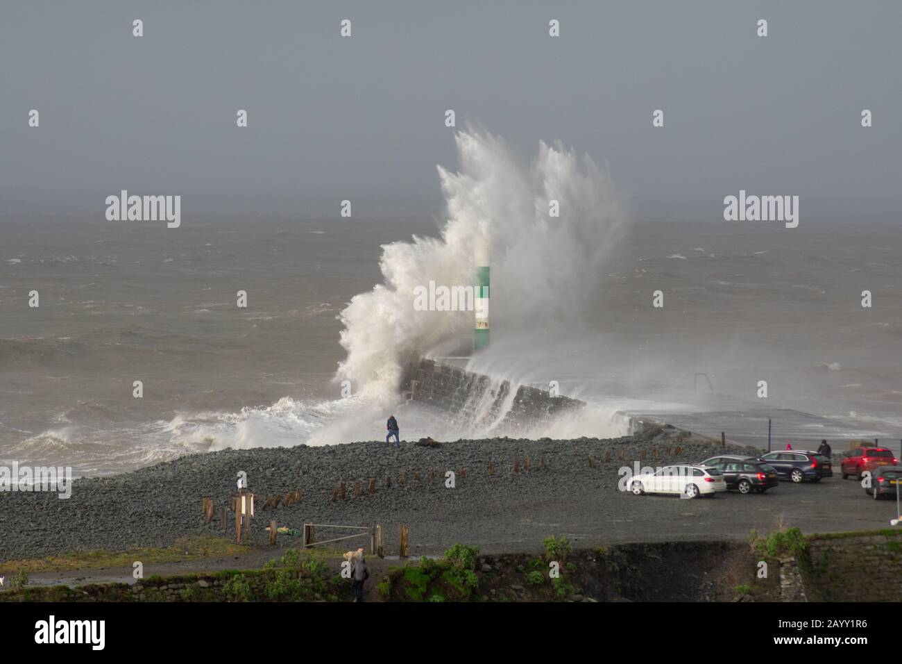 Die Sturmwinde, die über 60mph Uhr stürmen, und die morgendliche Flut verbinden sich und bringen riesige Wellen über die Irische See, um Aberystwyth zu schlagen. Stockfoto