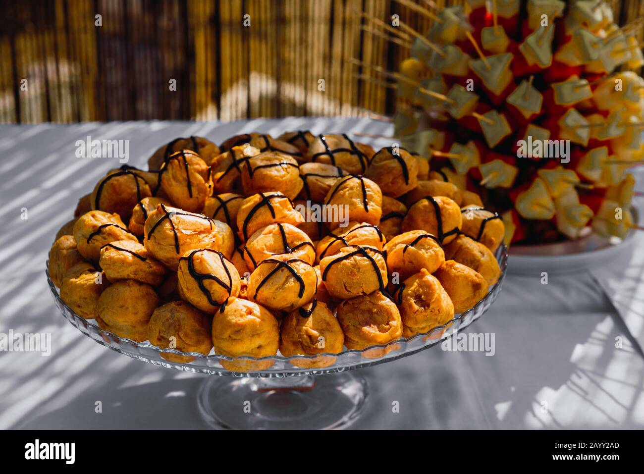 Gericht voller köstlicher und süßer Profiteroles, gefüllt mit kalter Creme. Stockfoto