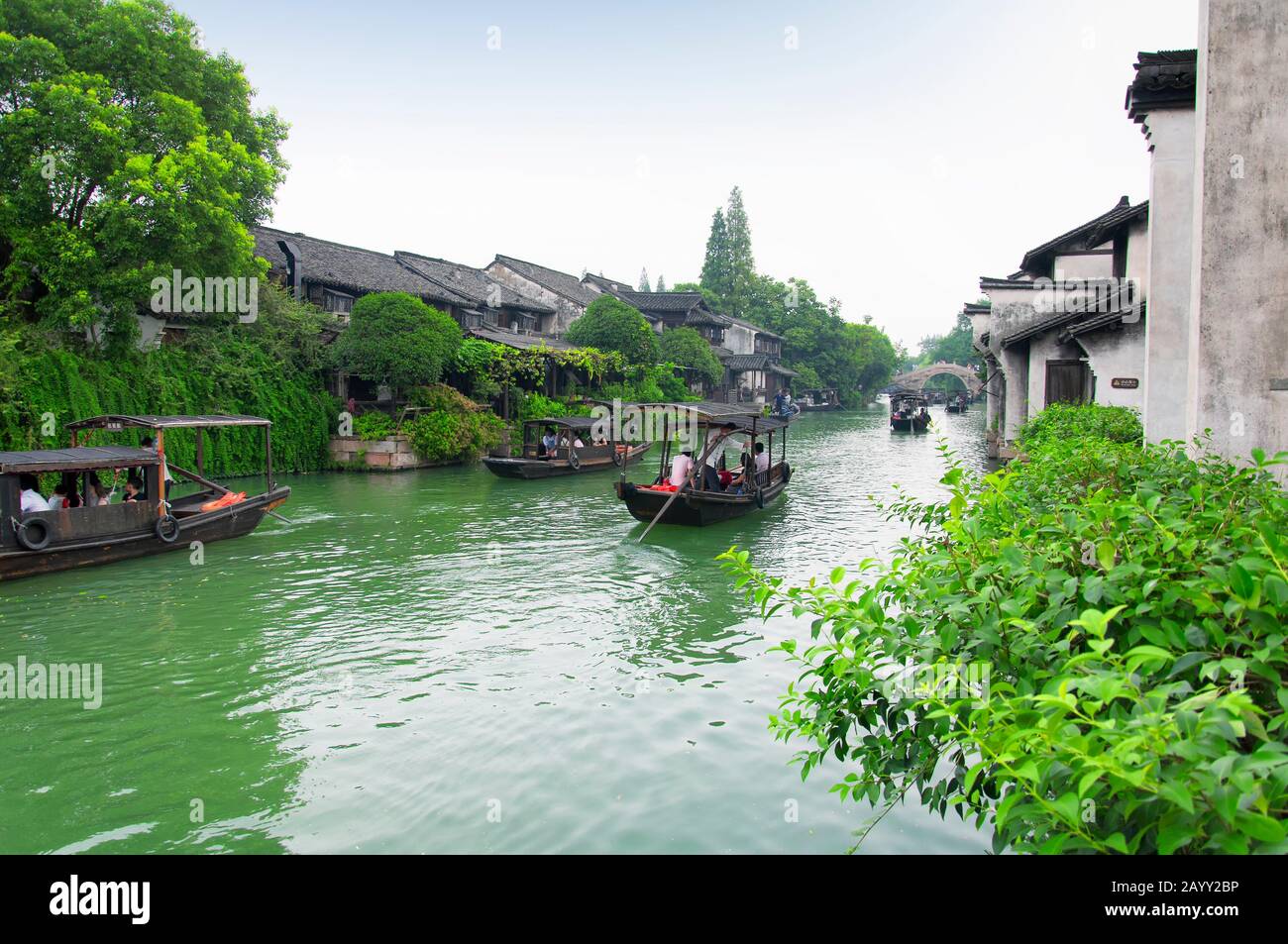 Wuzhen, China. August 2015. Touristenboote auf den Wasserkanälen in der Wasserstadt Wuzhen an einem übergiebelten Tag in der chinesischen Provinz Zhejiang. Stockfoto
