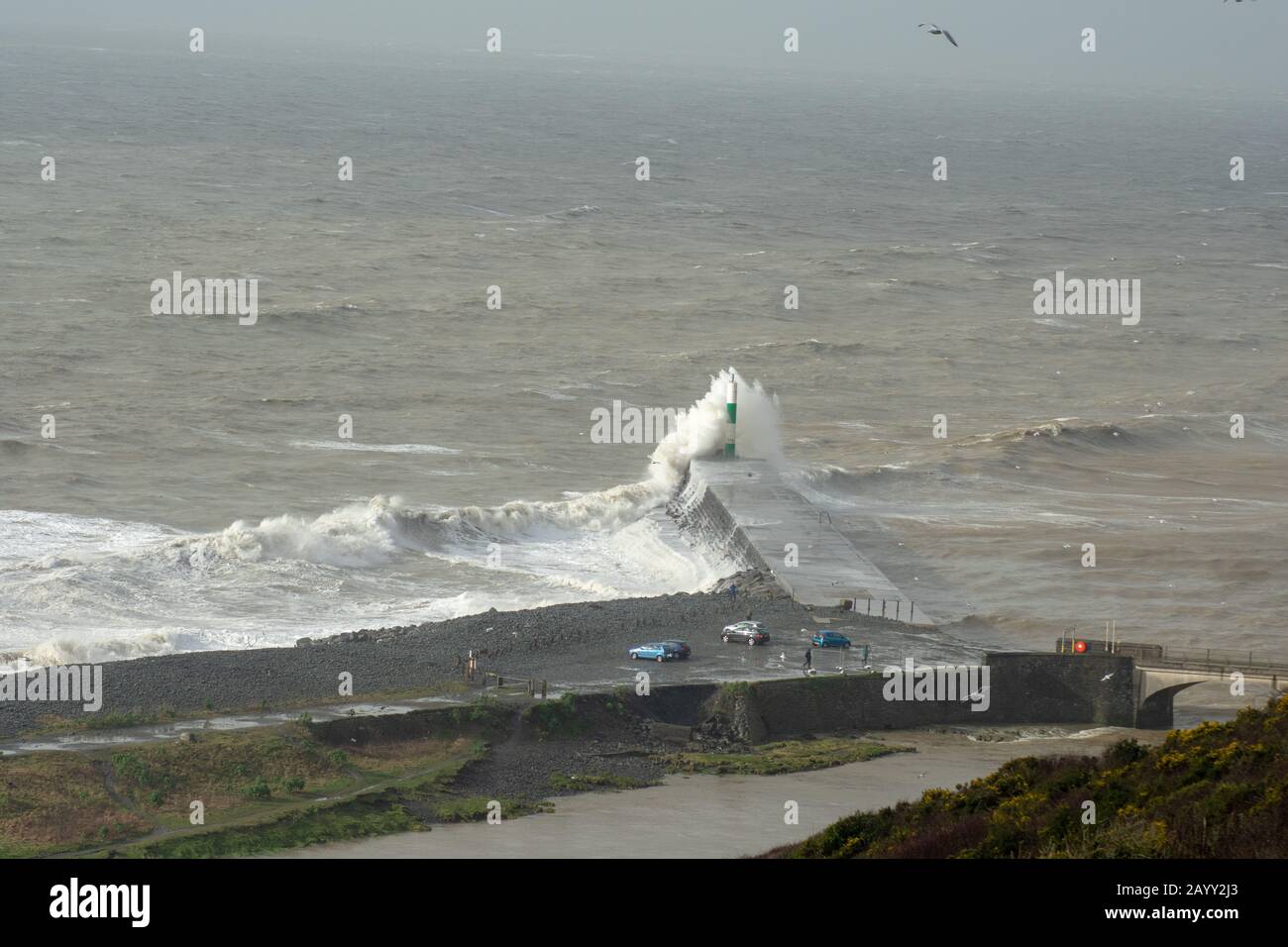 Die Sturmwinde, die über 60mph Uhr stürmen, und die morgendliche Flut verbinden sich und bringen riesige Wellen über die Irische See, um Aberystwyth zu schlagen. Stockfoto