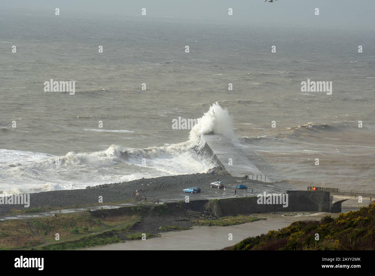 Die Sturmwinde, die über 60mph Uhr stürmen, und die morgendliche Flut verbinden sich und bringen riesige Wellen über die Irische See, um Aberystwyth zu schlagen. Stockfoto
