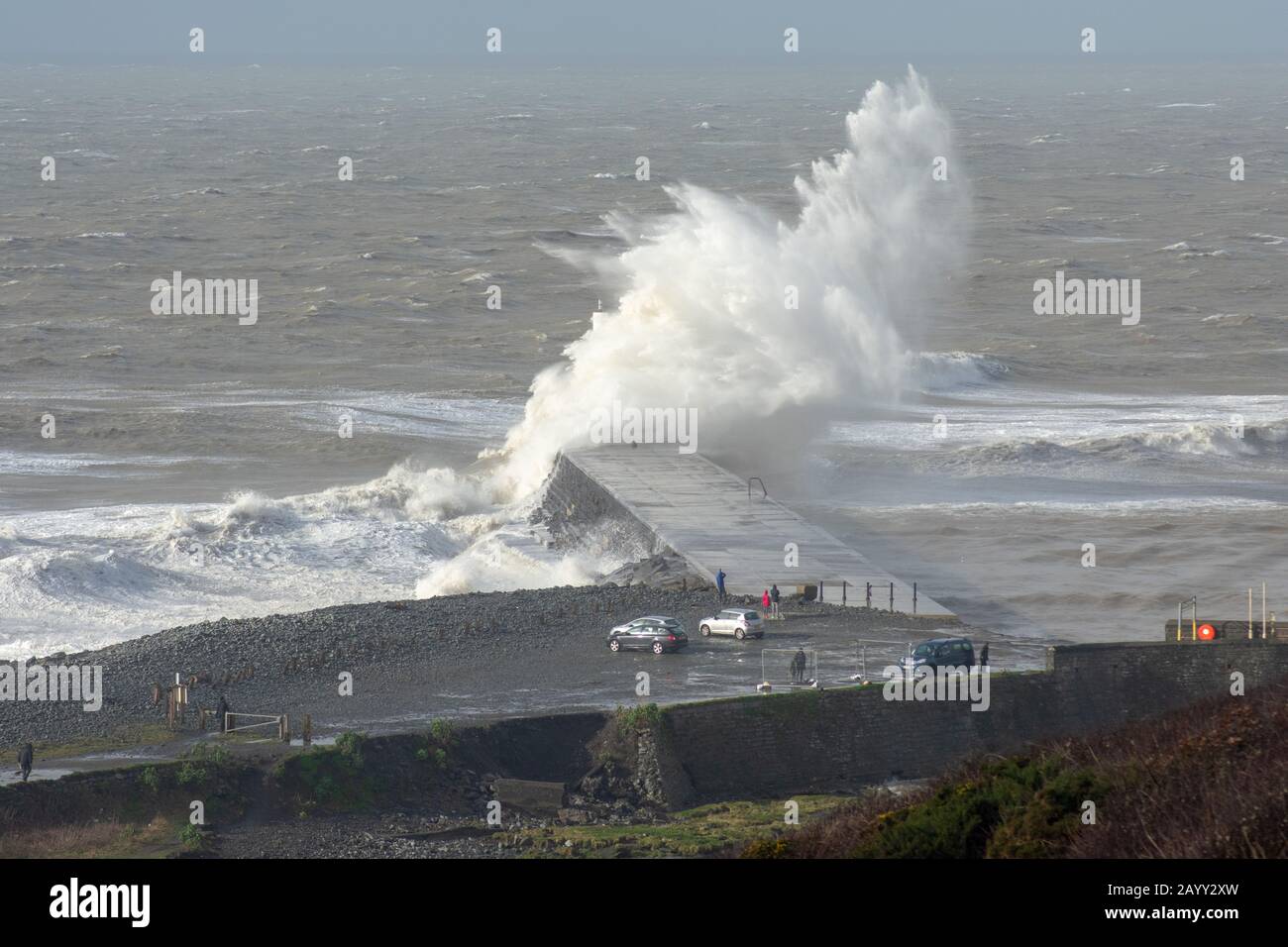 Die Sturmwinde, die über 60mph Uhr stürmen, und die morgendliche Flut verbinden sich und bringen riesige Wellen über die Irische See, um Aberystwyth zu schlagen. Stockfoto