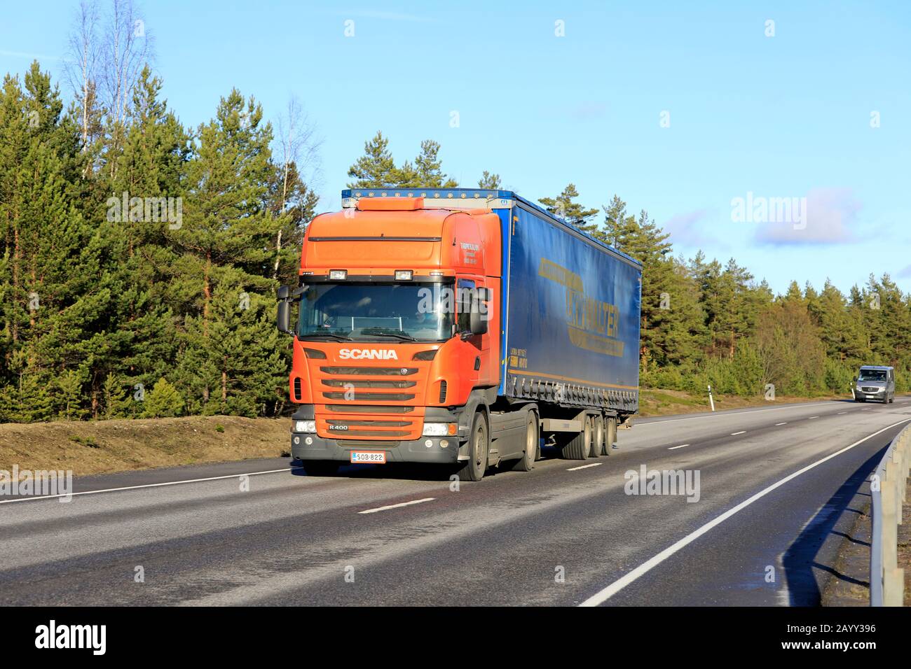 Orange Scania Truck von Tarmekal Oy zieht im Frühjahr den LKW Walter Anhänger in Richtung Hafen von Hanko entlang der Autobahn 25. Hanko, Finnland. Februar 2020. Stockfoto