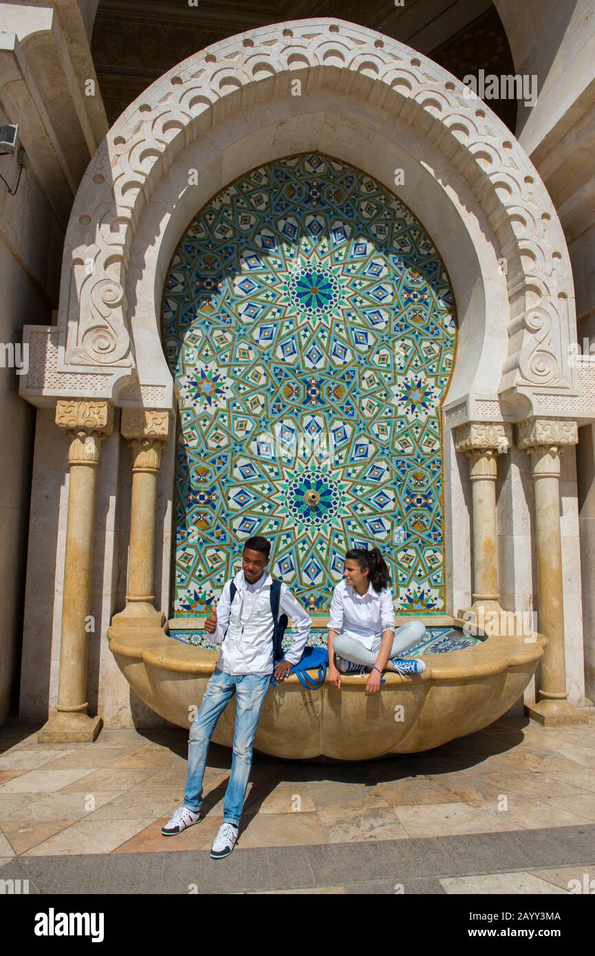 Marokkanische Teenager fotografieren an einem Brunnen in der Hassan-II-Moschee oder in Grande Mosquee Hassan II. In Casablanca, der größten Moschee in den Mukenkedern Stockfoto
