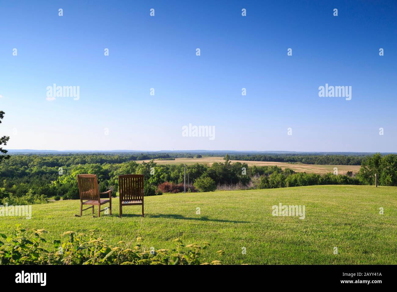Stühle auf Rasen mit Blick auf die Landschaft, Cedar Crest Lodge, Pleasanton, Kansas, USA. Stockfoto