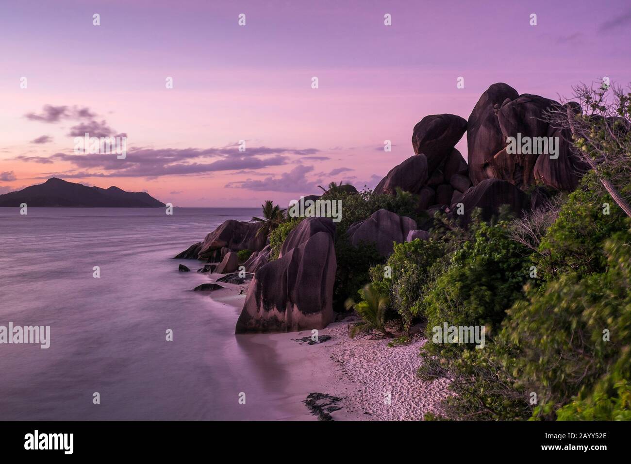 Dämmerung auf Felsen und Meer am Strand von Source D Argent auf La Digue, Seychellen Stockfoto