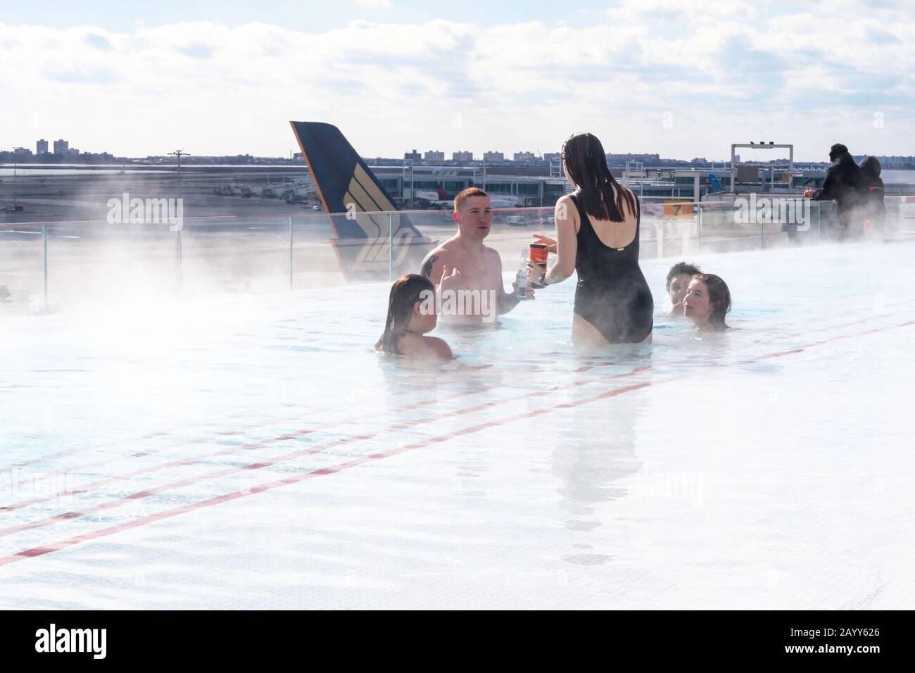 Gäste, die den Infinity-Pool auf dem Dach im TWA Hotel am John F. Kennedy Airport in New York City, USA, genießen Stockfoto