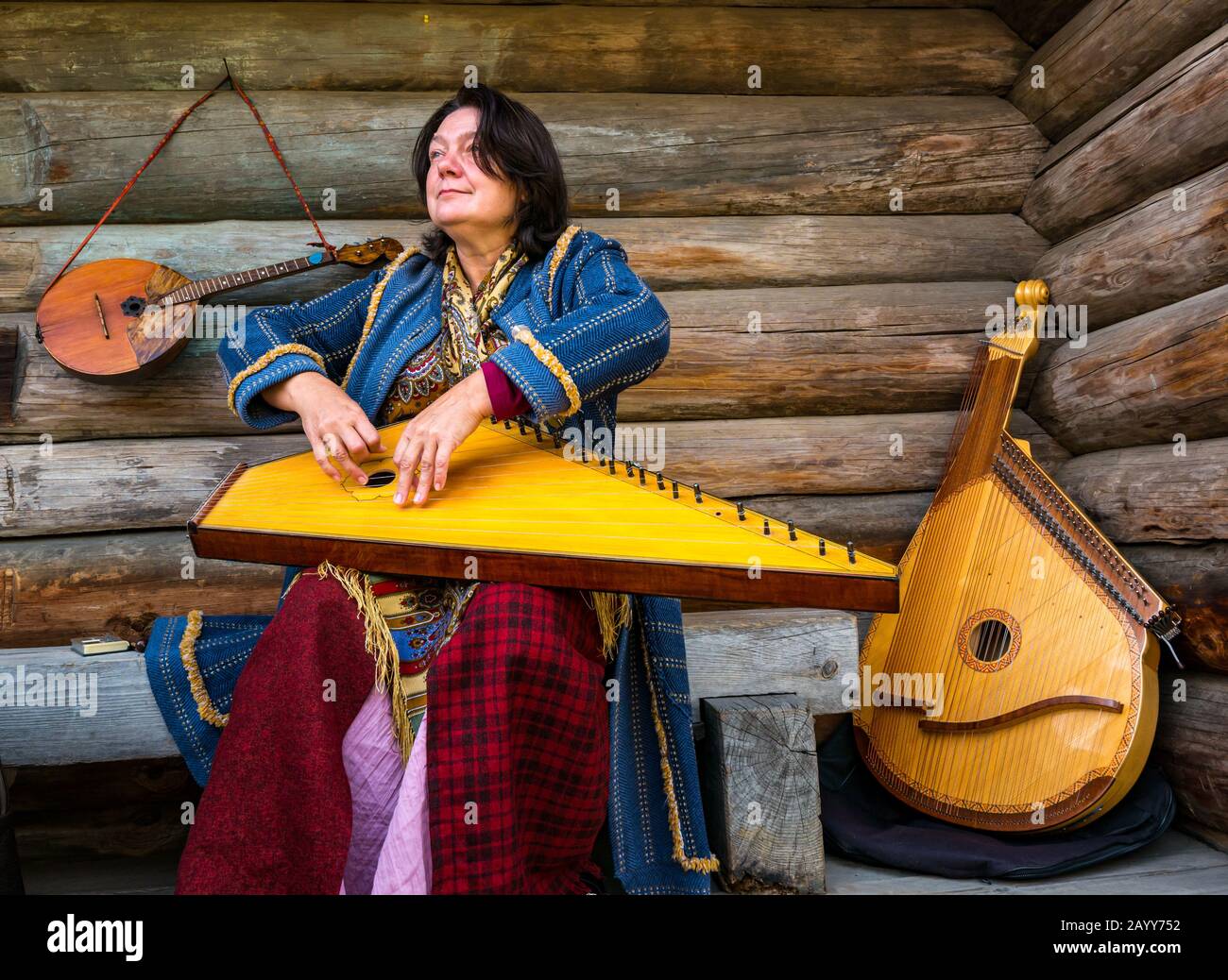 Frau in der Zeit Kostüm spielt Zither oder gusli Streichinstrument, Taltsy Museum of Wooden Architecture, Irkutsk Region, Sibirien, Russland Stockfoto