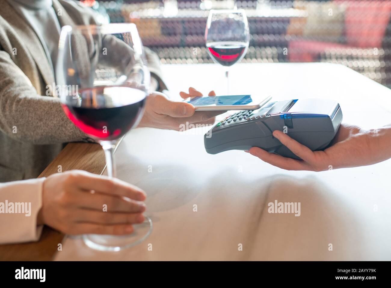 Horizontaler Schuss von nicht erkennbaren Personen, die für die Bestellung von Mahlzeiten in einem modernen Café mit NFC auf dem Smartphone zahlen Stockfoto