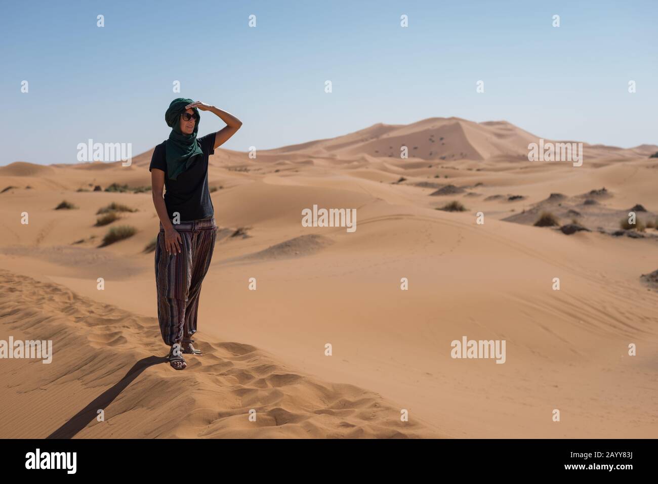 Frau, die die Horizontdünen in der marokkanischen Sahara-Wüste betrachtet. Stockfoto