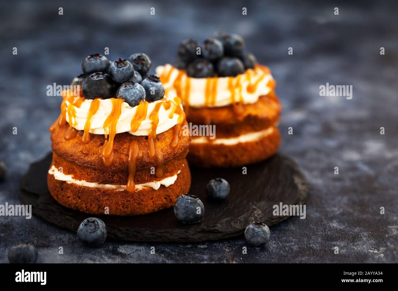 Hausgemachte Karotten individuelle Kuchen mit Karamellsoße, Frischkäse und frischen Blaubeeren Stockfoto