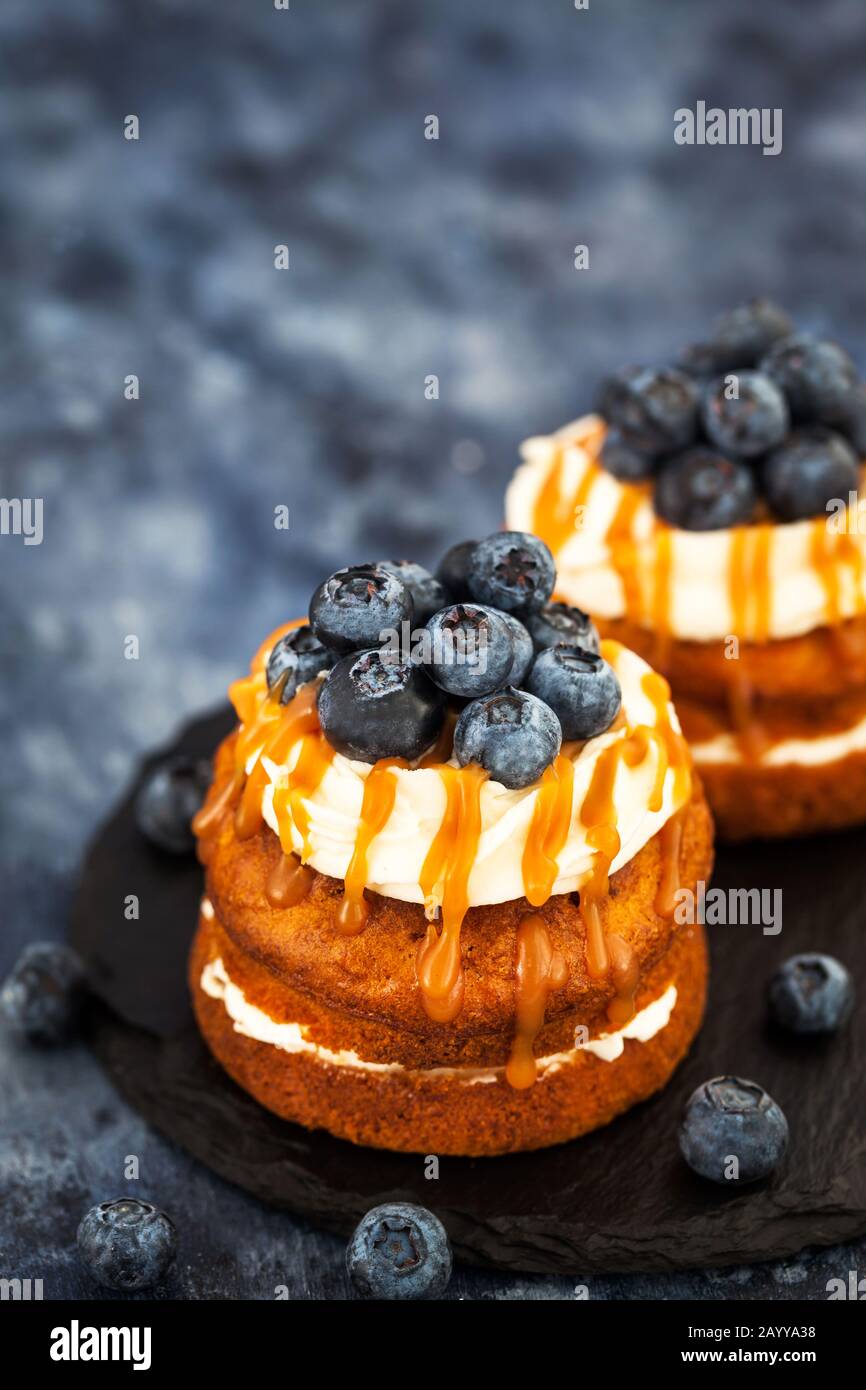 Hausgemachte Karotten individuelle Kuchen mit Karamellsoße, Frischkäse und frischen Blaubeeren Stockfoto