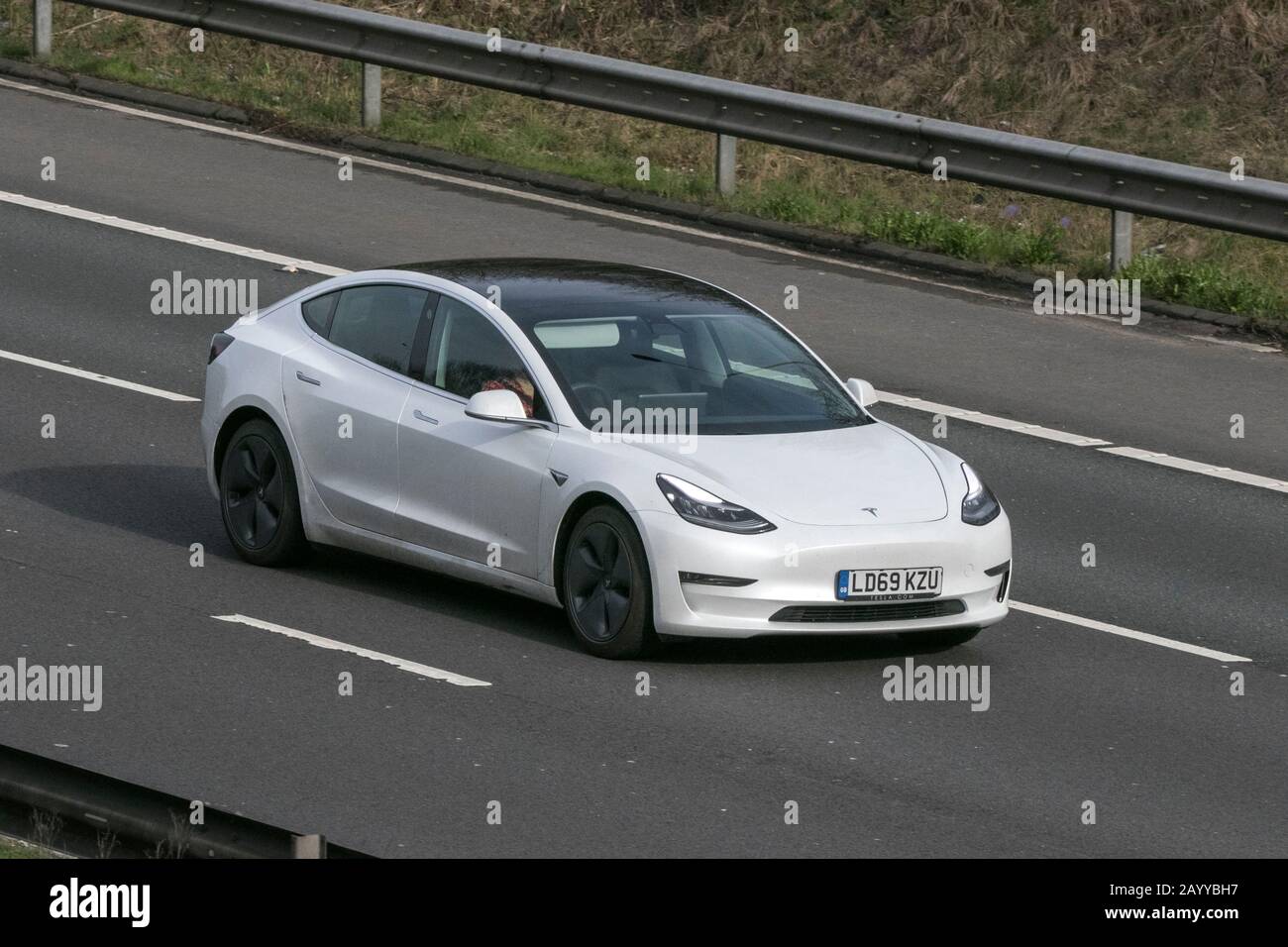 2019 weißer Tesla Model 3 Long Range AWD; Fahrzeugbewegung auf der Autobahn M6 in der Nähe von Preston in Lancashire Stockfoto