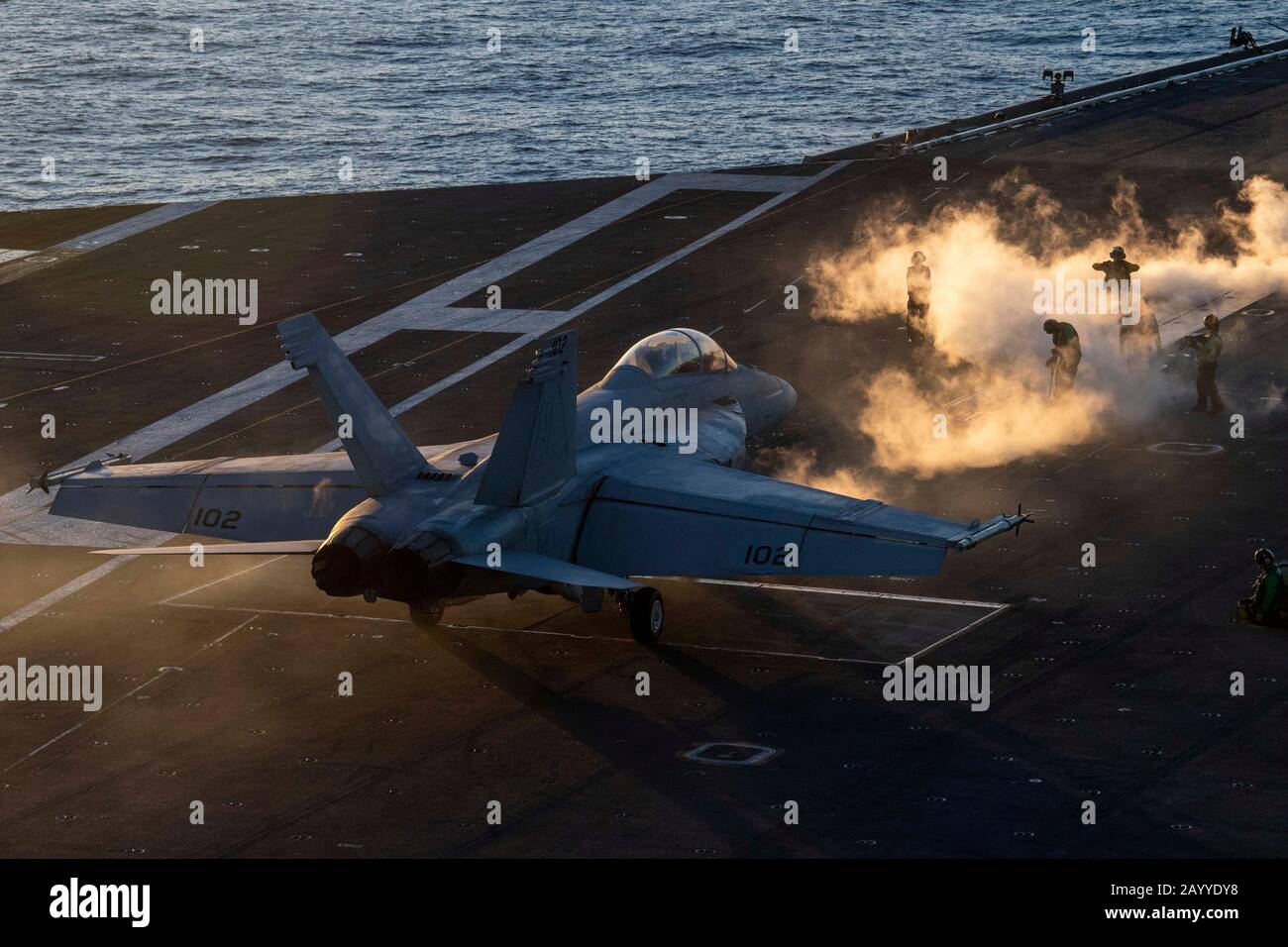 Die Decksbesatzung der US-Marine ist an einem kalten Tag in Dampf eingehüllt, während sie ein F/A-18F Super Hornet Kampfflugzeug vorbereitet, das an den Schwertkämpfer des Strike Fighter Squadron 32 angebracht ist, um während der Operationen vom Flugdeck des Flugzeugträgers der Nimitz-Klasse USS Dwight D. Eisenhower abzusteigen. 2020 im Atlantik. Stockfoto