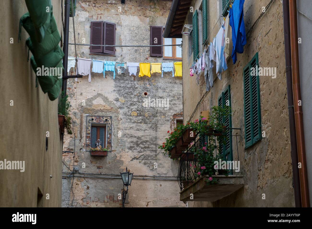In Pienza, Val d'Orcia, Toskana, Italien, hängt bunte Wäsche vor einem Haus zum Trocknen. Stockfoto