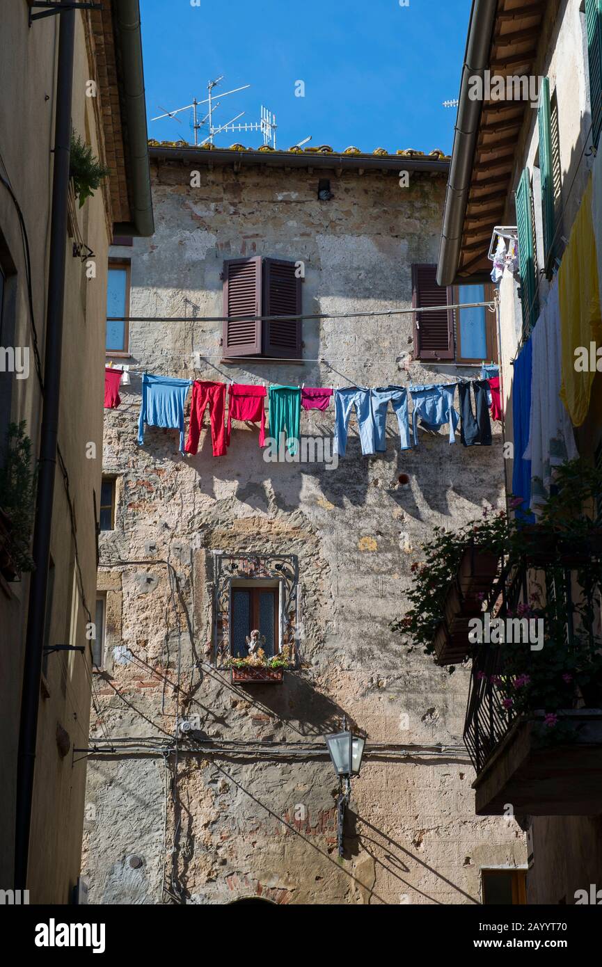 In Pienza, Val d'Orcia, Toskana, Italien, hängt bunte Wäsche vor einem Haus zum Trocknen. Stockfoto