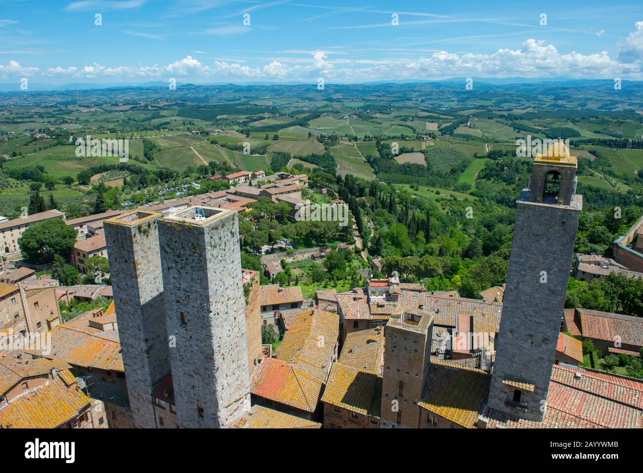 Blick von einem Turm der mittelalterlichen ummauerten Bergstadt San Gimignano in der Toskana, Italien und der umliegenden Landschaft. Stockfoto