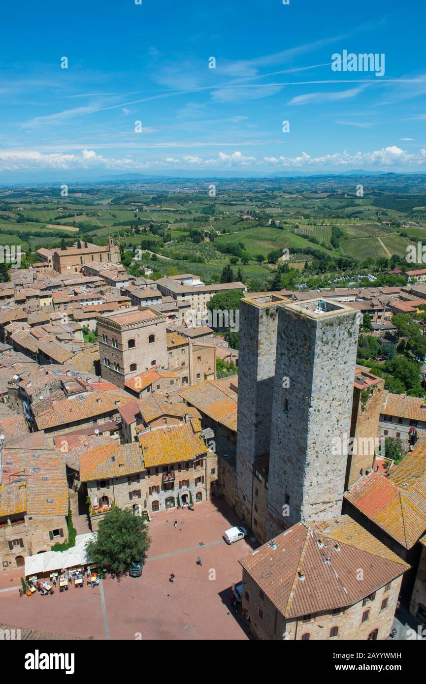 Blick von einem Turm der mittelalterlichen ummauerten Bergstadt San Gimignano in der Toskana, Italien und der umliegenden Landschaft. Stockfoto
