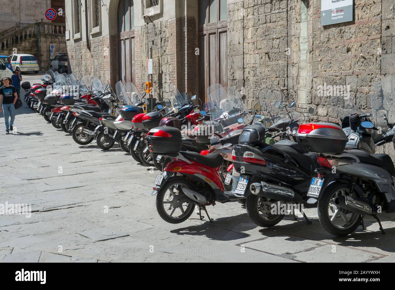 Straßenszene mit geparkten Motorrollern in Siena in der Toskana, Italien. Stockfoto