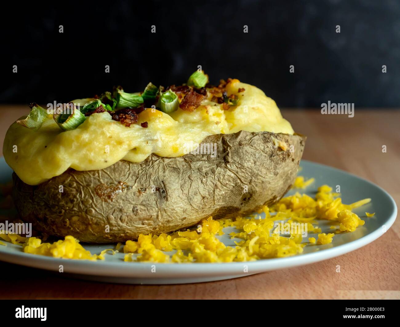 Zweimal Gebackene Kartoffel Mit Hengst, Bacon und Cheddar-Käse, Perfekt Gebacken auf einer grauen Platte, Die Mit Mehr Käse Garniert wurde. Lecker hausgemachter Foo Stockfoto