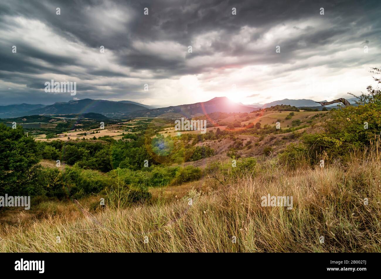 Dramatischer Sonnenuntergang im Bergtal. Bewölkter Himmel mit starkem Wind in der Provence, Frankreich Stockfoto