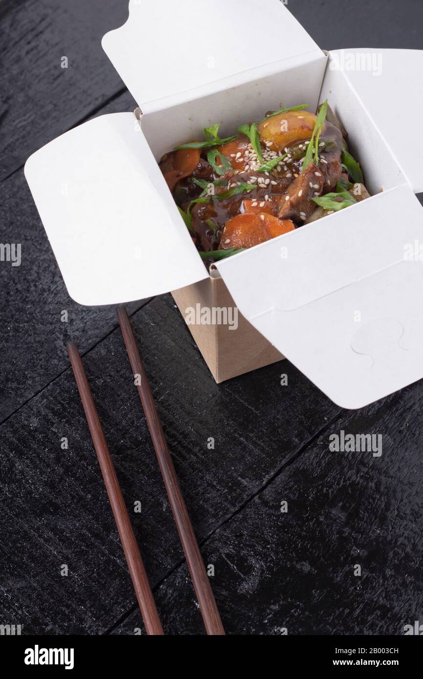 Chinesische Küche mit süßem und Saurem Huhn, Orange oder Lemon Chicken - in einem Behälter Mit Schopsticsk Herausnehmen Stockfoto