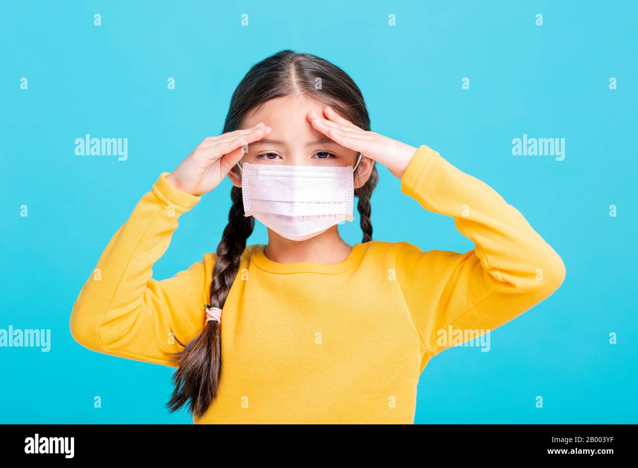 Kind des kranken Mädchens in medizinischer Maske isoliert auf blauem Hintergrund Stockfoto