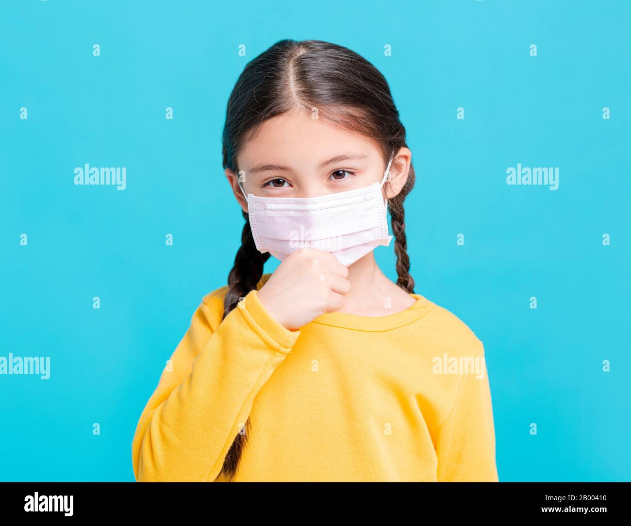 Kind des kranken Mädchens in medizinischer Maske isoliert auf blauem Hintergrund Stockfoto