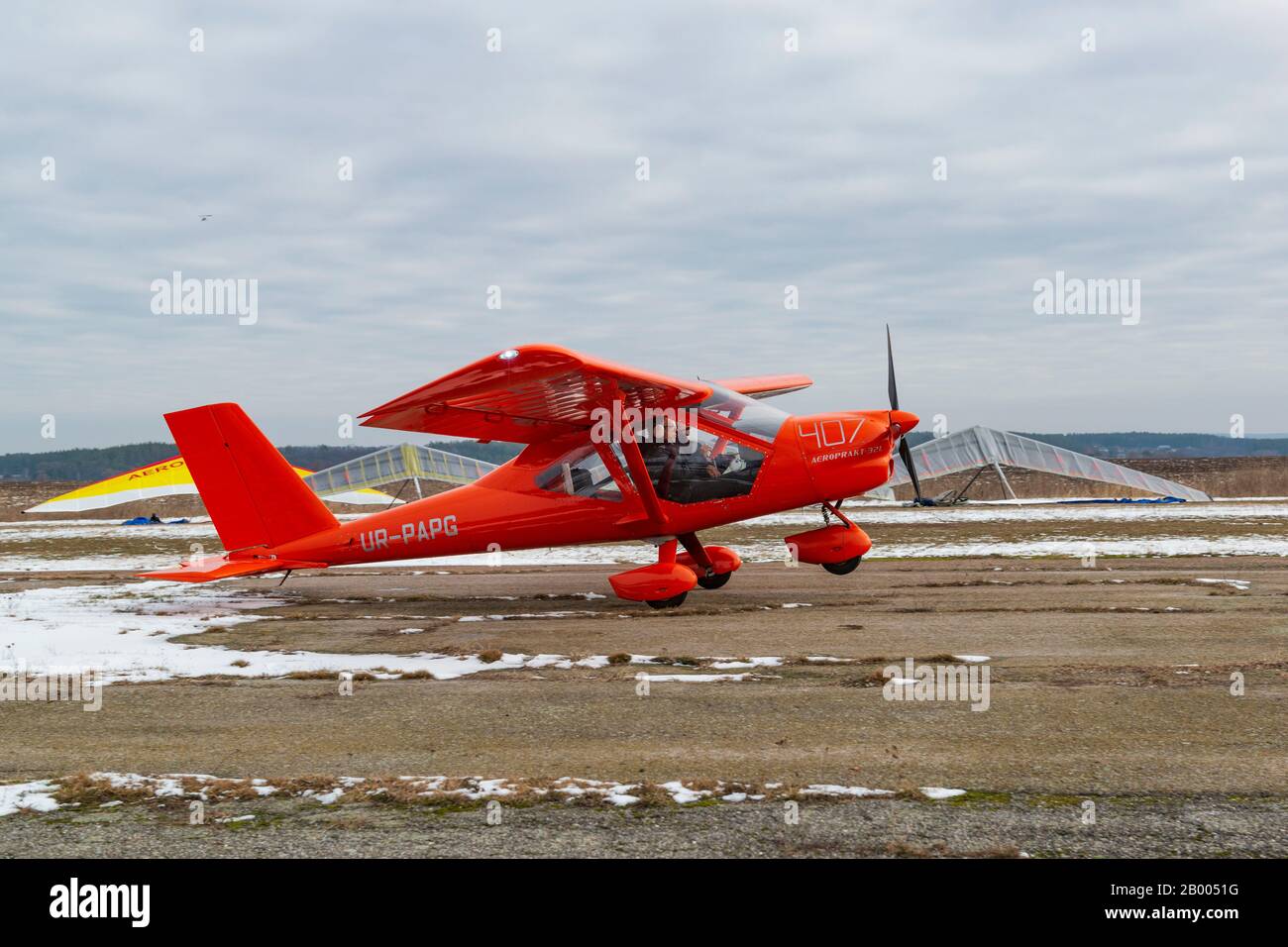 2020-02-09 Byshiv, Ukraine. Kleines rotes Flugzeug fliegt vom örtlichen Flugplatz. Ultraleichter Flug mit dem Flugzeug Stockfoto