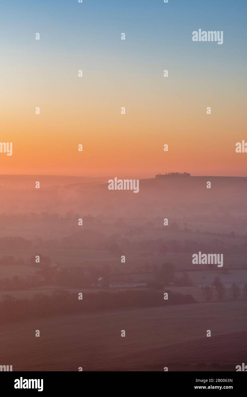 Blick vom Martinsell Hill auf einen nebligen Wintermorgen bei Sonnenaufgang. In der Nähe von Oare, Vale of Pewsey, Wiltshire, England Stockfoto