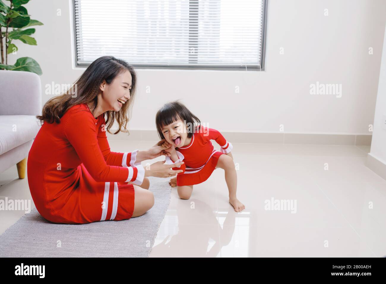 Junge Mutter spielt mit ihrer Tochter im Wohnzimmer. Stockfoto