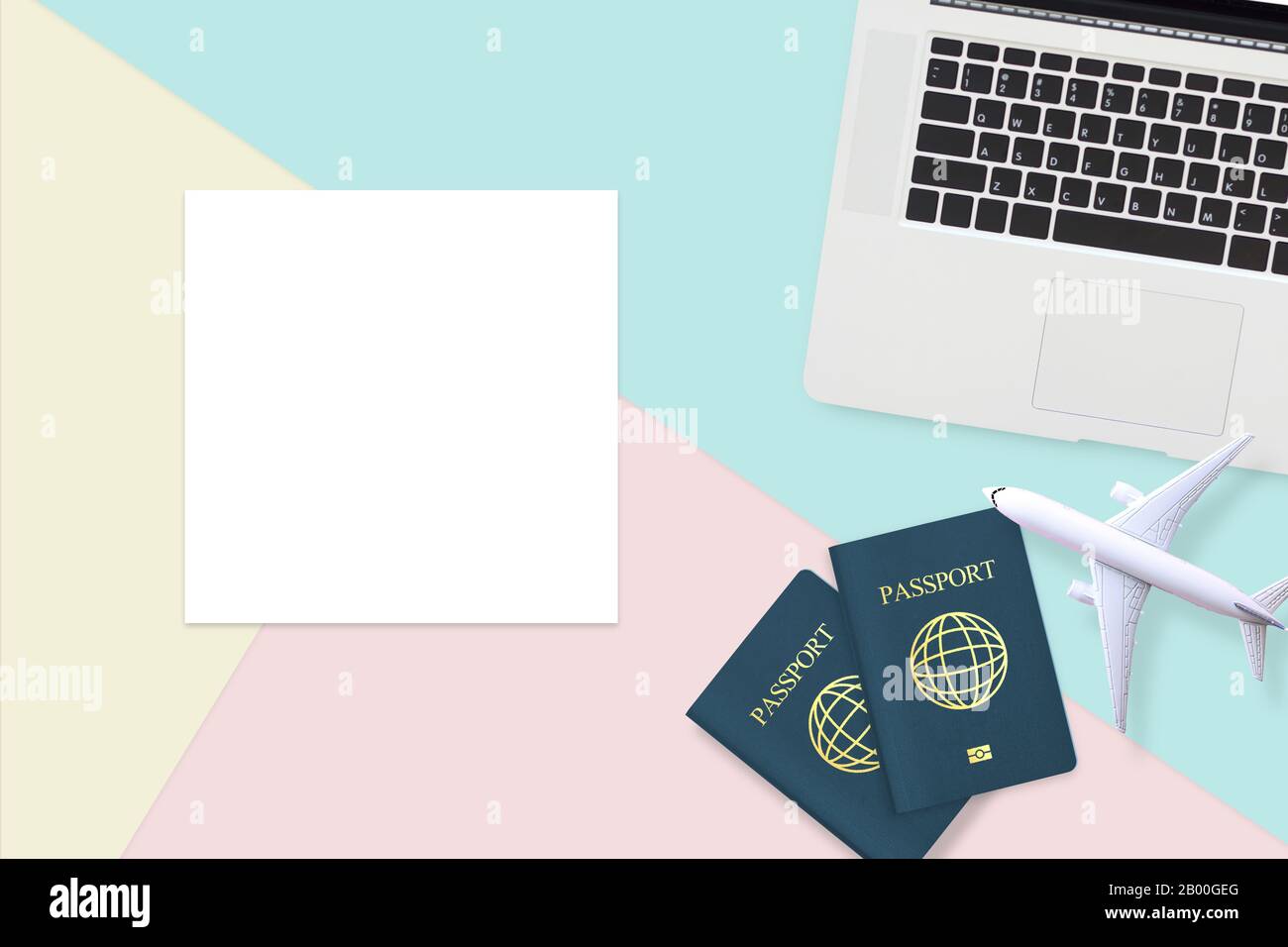 Flacher Pass, weißes Flugzeugmodell und Computerlaptop auf pastellblauem, gelbem und pinkfarbenem Hintergrund und leerem weißem Papier mit Kopierraum. T Stockfoto