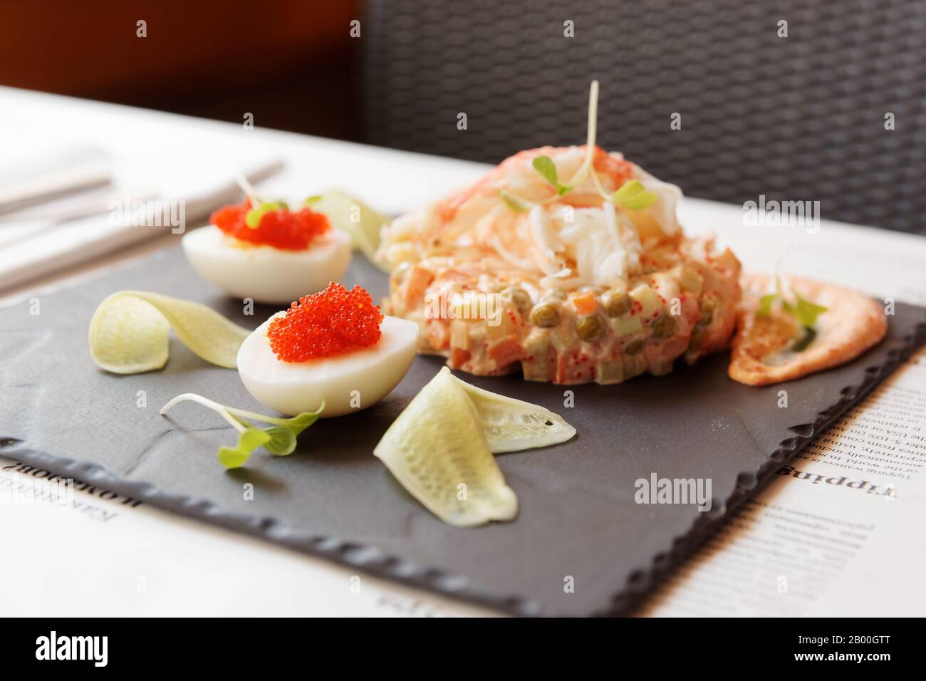 Russischer Salat mit Krabbenfleisch auf Restauranttisch Stockfoto