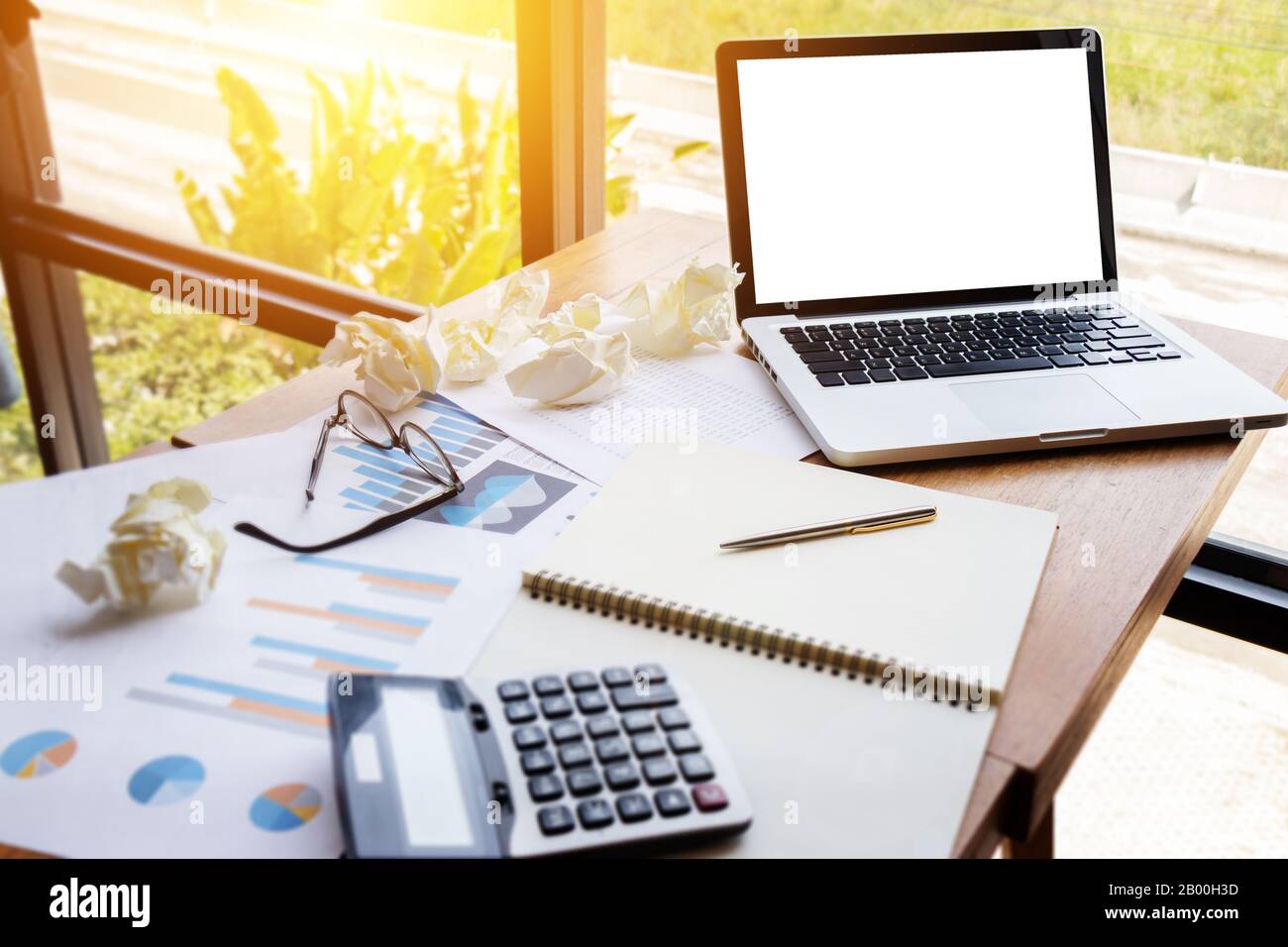 Diagramm- und Grafikkonto mit Rechner auf dem Tisch Arbeitsplatz mit leerem Bildschirm Laptop .Business Finanzen, Investitionen, Audit und Analyse. Stockfoto