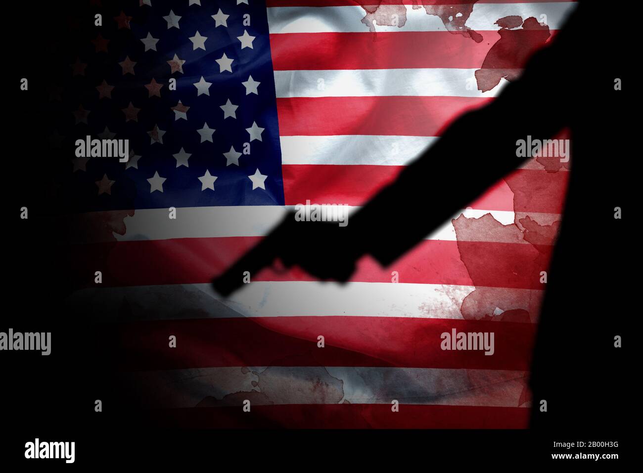 Handfeuerwaffe in Schusshand mit Blutfleck auf amerikanischer Flagge. Reform Waffenkontrolle in Amerika Konzept Stockfoto