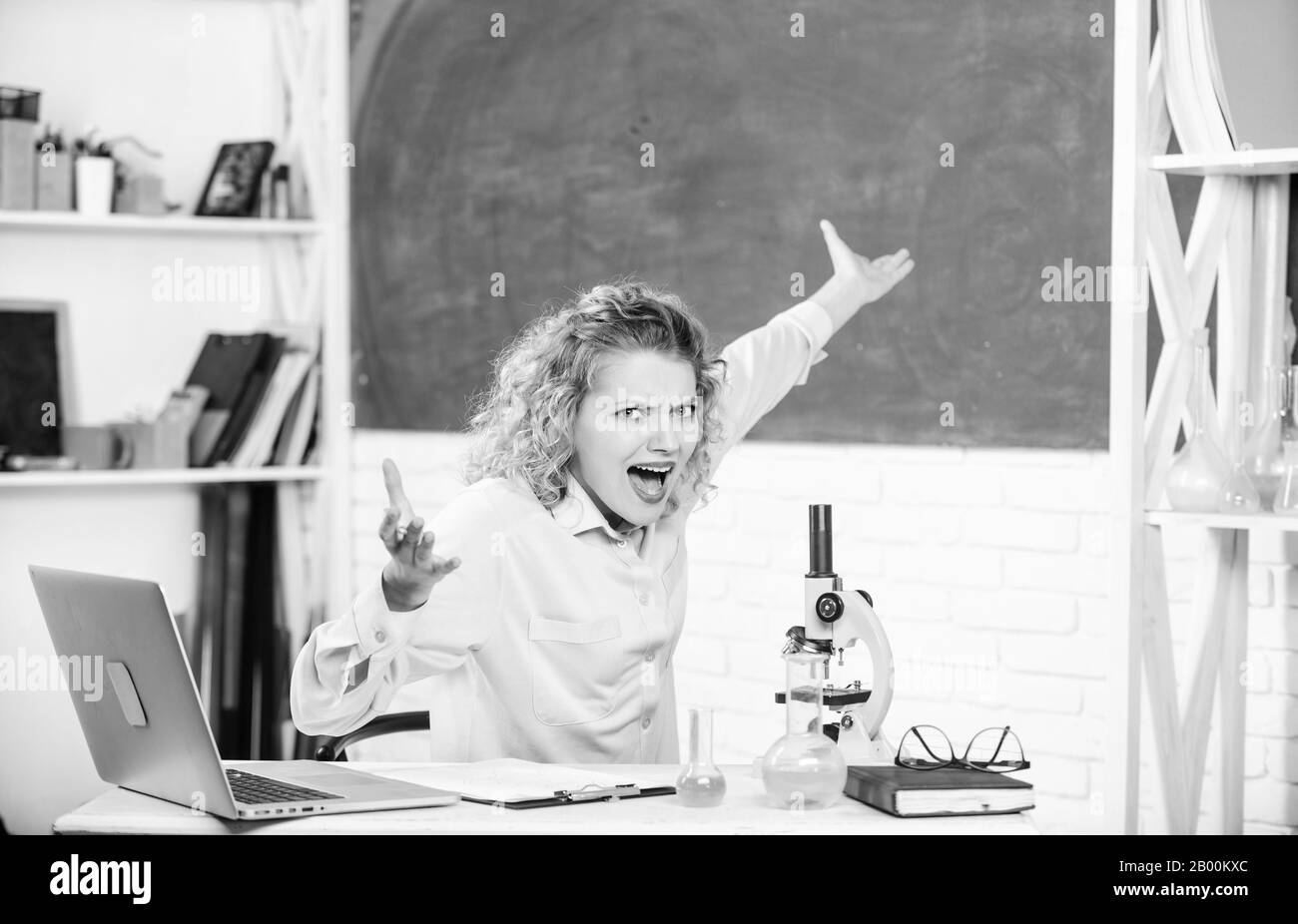 Frau Tutor oder Student am Schreibtisch mit Laptop und die Ausstattung der Schulen und Schreibwaren. Emotionale Steuerung. Emotionale Menschen Konzept. Emotionale Lehrerin Erzieherin im Klassenzimmer Tafel Hintergrund. Stockfoto