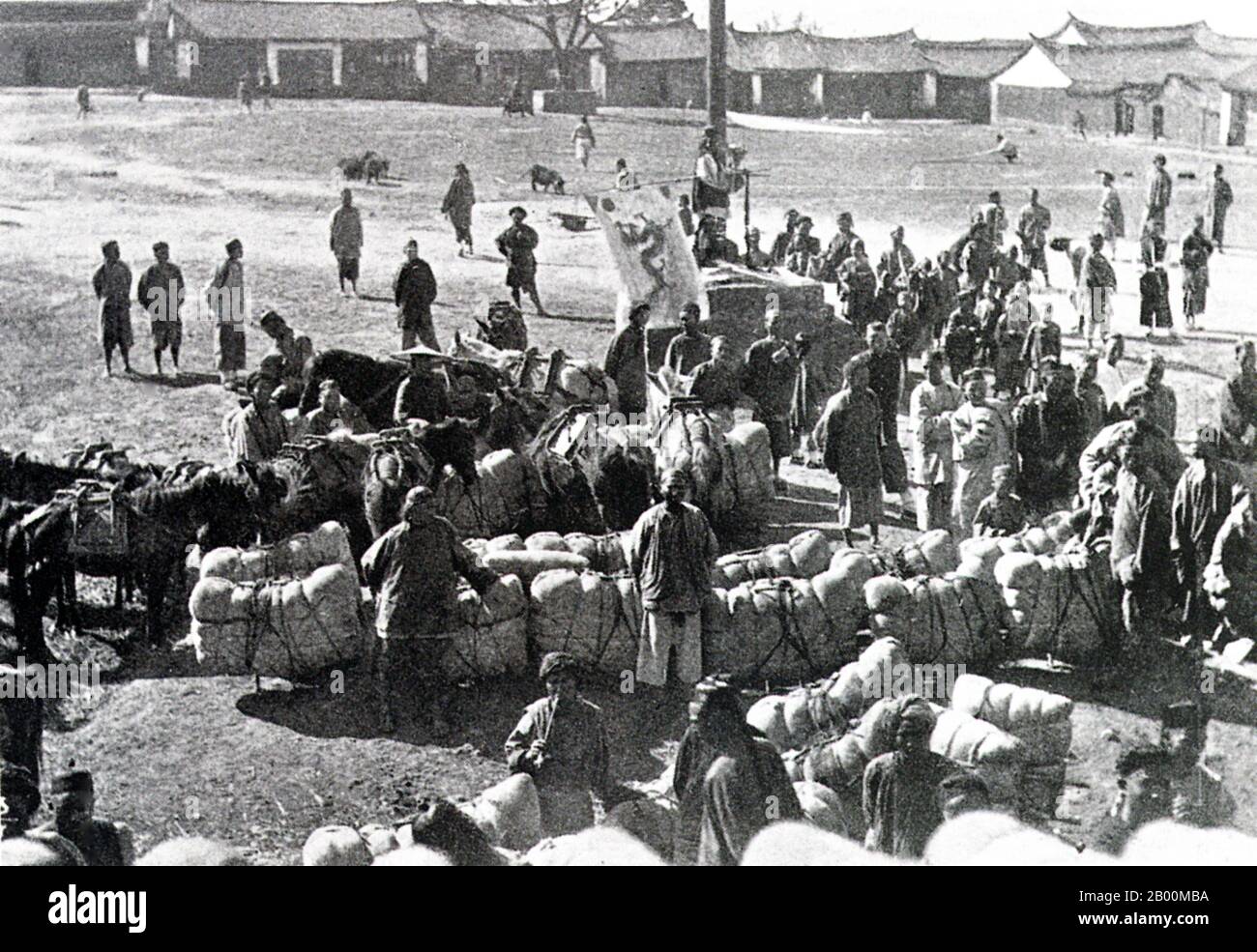 China: Eine Pu'er Baumwollkarawane unter der Qing Flagge im späten 19. Jahrhundert. Die Tea Horse Road (Cha Ma Dao) war ein Netzwerk von Maultierkarawanenwegen, die sich durch die Berge von Yunnan, Sichuan und Tibet im Südwesten Chinas schlängeln. Es wird auch manchmal als die Southern Silk Road und Ancient Tea and Horse Road bezeichnet. Seit etwa tausend Jahren war die Ancient Tea Route eine Handelsverbindung von Yunnan, einer der ersten Teeanbauregionen, nach Indien über Burma, nach Tibet und über die Provinz Sichuan nach Zentralchina. Neben Tee trugen die Maultierkarawanen Salz. Stockfoto