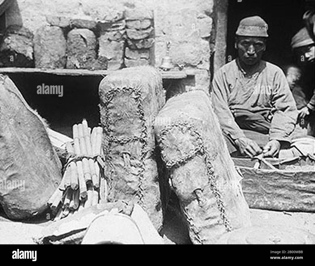 China: Teeladen mit Tüten Ziegel-Tee, Lhasa, ca. 1928. Die Tea Horse Road (Cha Ma Dao) war ein Netzwerk von Maultierkarawanenwegen, die sich durch die Berge von Yunnan, Sichuan und Tibet im Südwesten Chinas schlängeln. Es wird auch manchmal als die Southern Silk Road und Ancient Tea and Horse Road bezeichnet. Seit etwa tausend Jahren war die Ancient Tea Route eine Handelsverbindung von Yunnan, einer der ersten Teeanbauregionen, nach Indien über Burma, nach Tibet und über die Provinz Sichuan nach Zentralchina. Neben Tee trugen die Maultierkarawanen Salz. Stockfoto