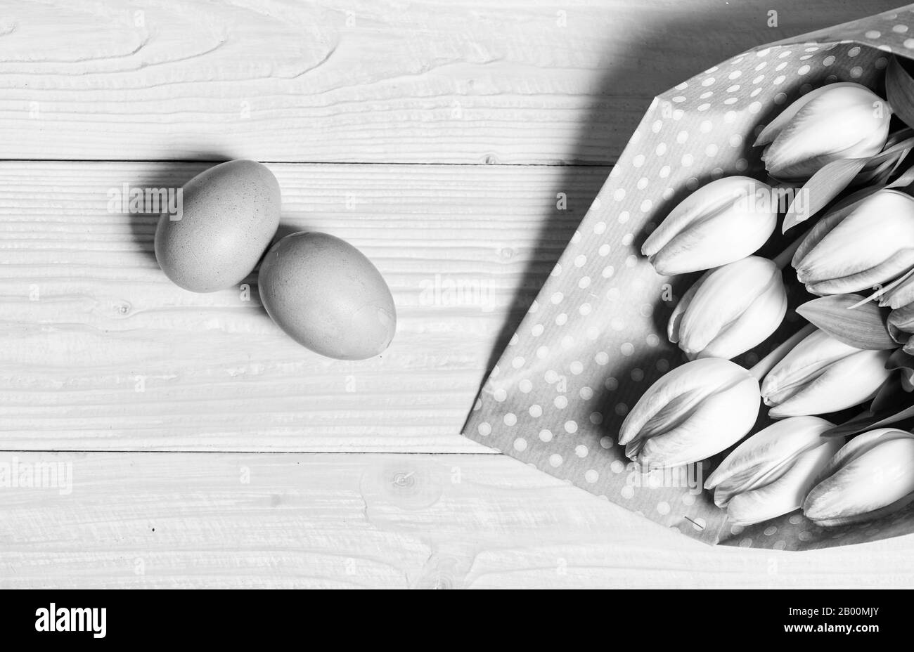 Ostern steht vor der Tür. Bunte helle Eier und frisches Bukett Tulpe Blumen auf gelben Hintergrund der Ansicht von oben. Frühling Urlaub. Tradition Feiern Sie das Osterfest. Frohe Ostern Saison. Ostern Eier Symbol. Feder vibes. Stockfoto