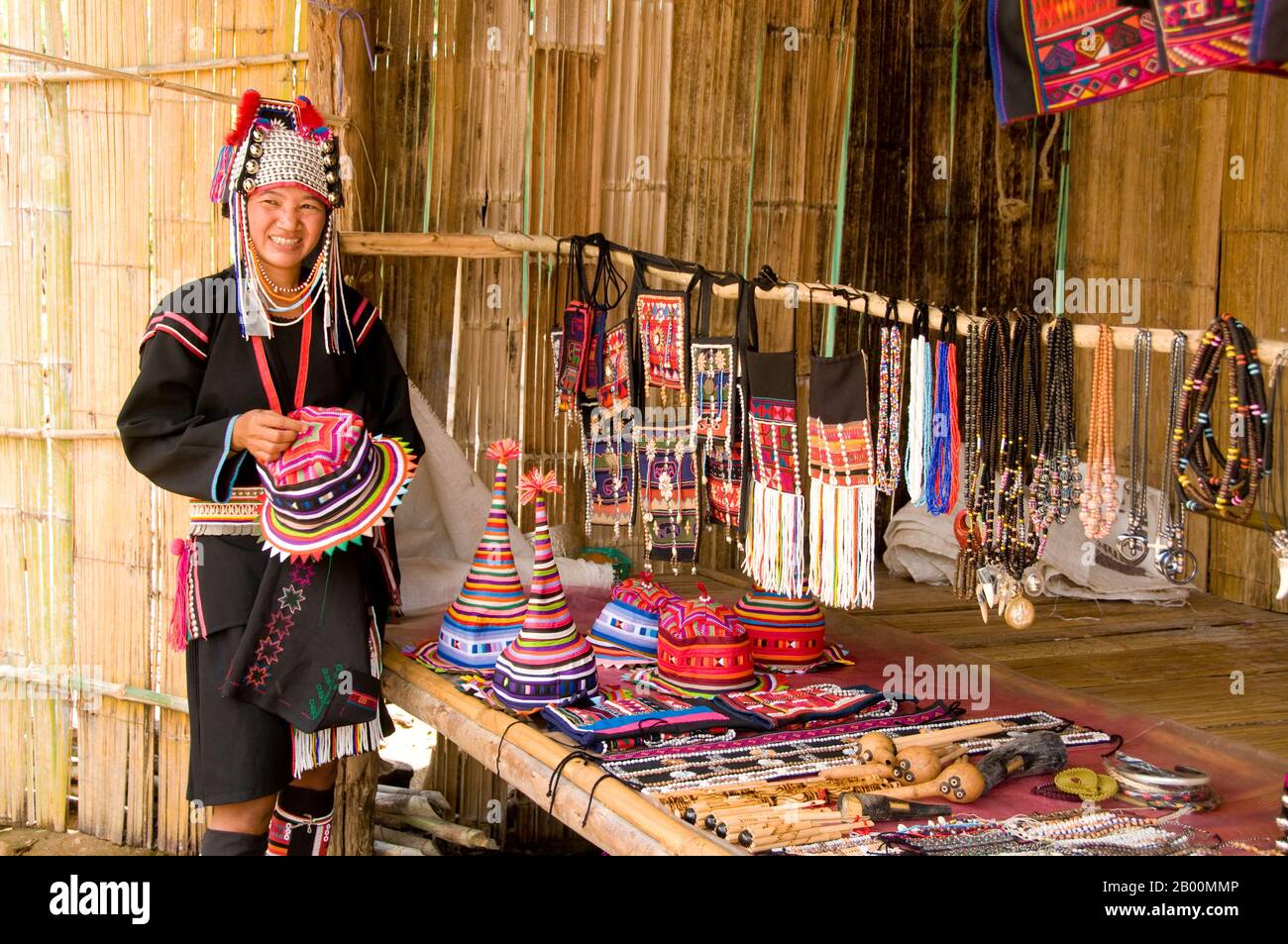 Thailand: Akha Frau verkauft traditionelles Kunsthandwerk in einem Dorf im Norden Thailands. Die Akha sind ein Hügelstamm von Subsistenzbauern, die für ihre Kunstfertigkeit bekannt sind. Die ethnische Gruppe mag vor etwa 1500 Jahren in der Mongolei entstanden sein. Die meisten der verbliebenen Akha-Völker sind heute in kleinen Dörfern zwischen den Bergen Chinas, Laos, Myanmar (Burma) und Nordthailand verteilt, wo sie zu den sechs wichtigsten Bergstämmen gehören. Die Akha begann in Thailand im frühen zwanzigsten Jahrhundert zu kommen und weiterhin zu einwandern, mit etwa 80,000 jetzt leben in Thailand. Stockfoto