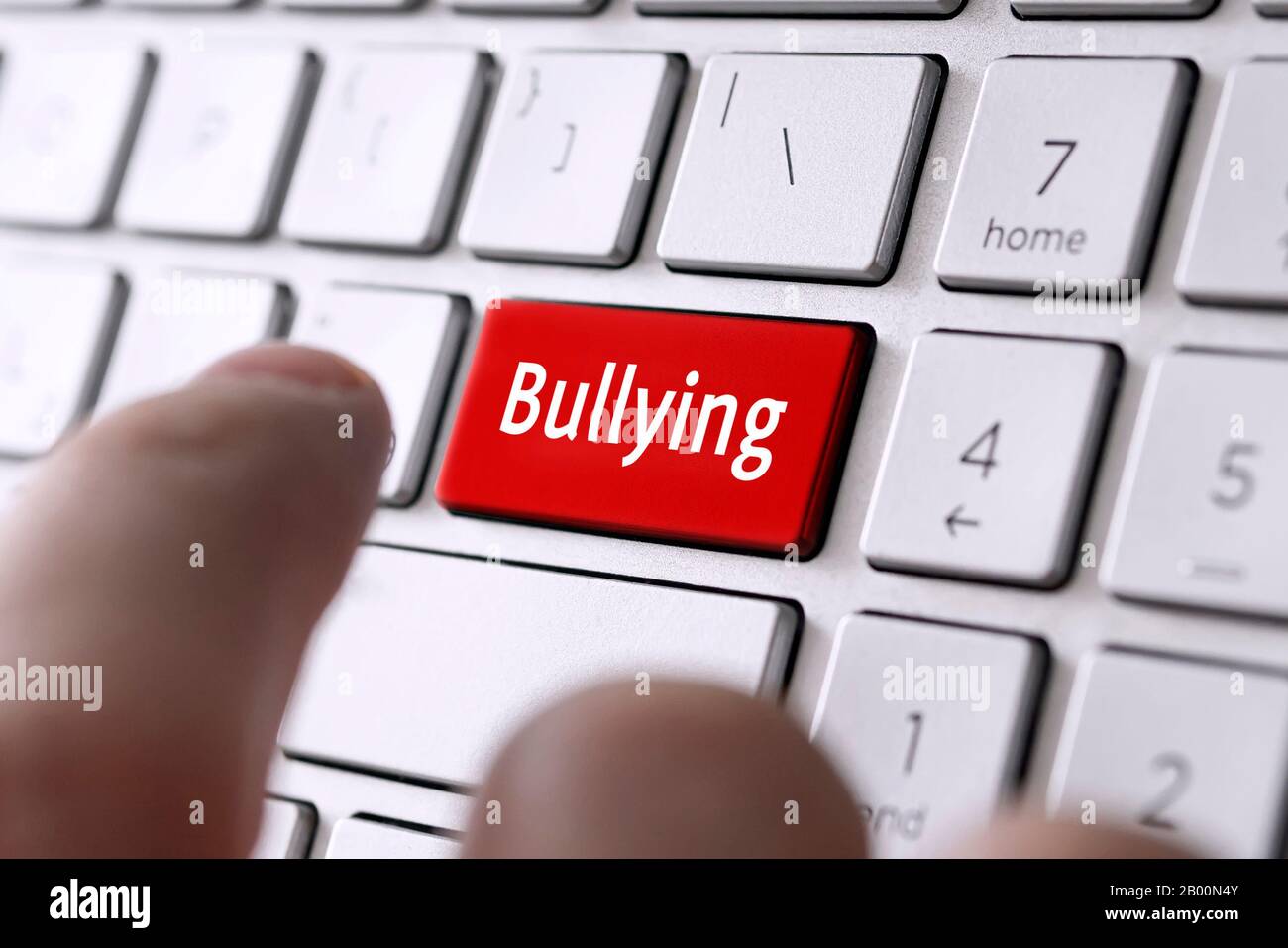 Das Wort Mobbing auf der grauen Tastatur des Computers. Das Konzept der Einschüchterung und Demütigung von Belästigungen im Netzwerk. Stockfoto