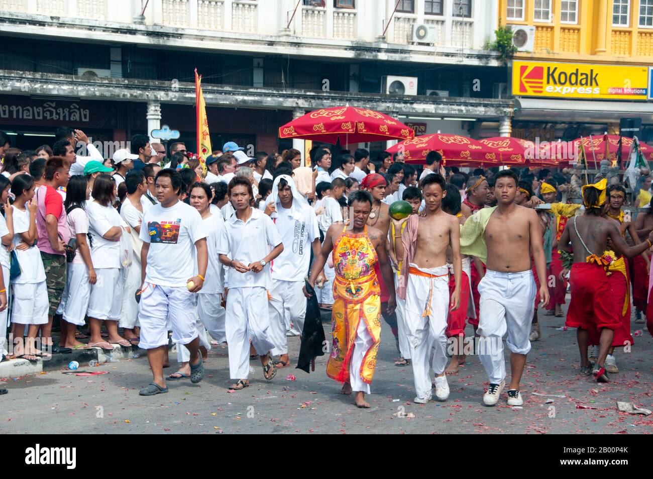 Thailand: Die "Ma Song" (mitgerissen Anhänger) und ihre Begleiter passieren die Straßen von Phuket Town, Phuket Vegetarian Festival. Das Vegetarische Festival ist ein religiöses Festival, das jährlich auf der Insel Phuket im Süden Thailands stattfindet. Es zieht Massen von Zuschauern wegen vieler der ungewöhnlichen religiösen Rituale an, die durchgeführt werden. Viele religiöse Anhänger werden sich mit Schwertern niederschlagen, ihre Wangen mit scharfen Gegenständen durchbohren und andere schmerzhafte Handlungen begehen. Stockfoto