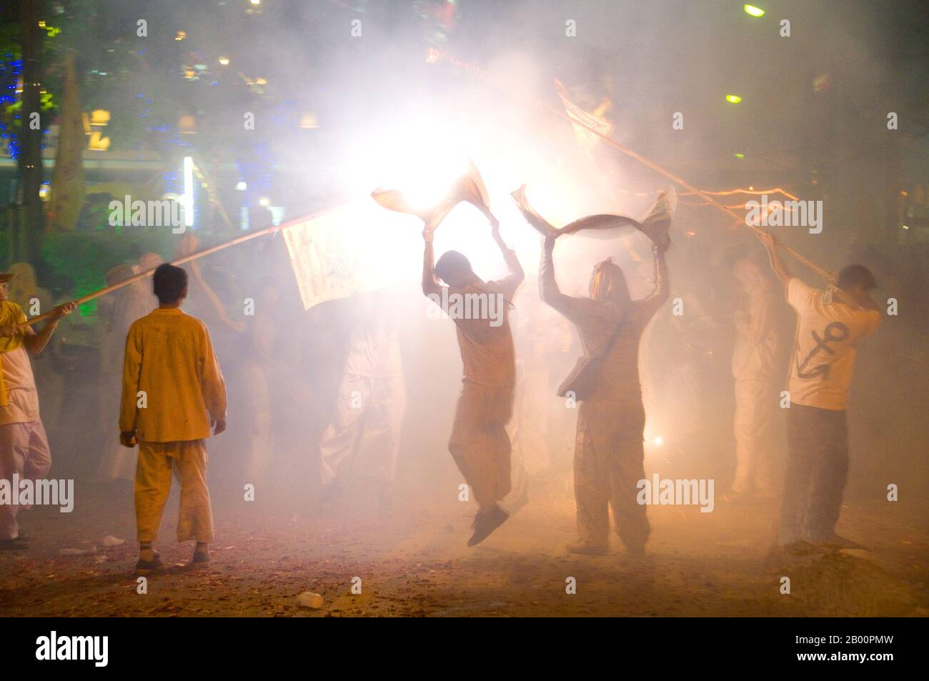 Thailand: Die Straßen von Phuket Town explodieren mit Feuerwerkskörpern, wenn die Parade vorbeizieht, Phuket Vegetarian Festival. Das Vegetarische Festival ist ein religiöses Festival, das jährlich auf der Insel Phuket im Süden Thailands stattfindet. Es zieht Massen von Zuschauern wegen vieler der ungewöhnlichen religiösen Rituale an, die durchgeführt werden. Viele religiöse Anhänger werden sich mit Schwertern niederschlagen, ihre Wangen mit scharfen Gegenständen durchbohren und andere schmerzhafte Handlungen begehen. Stockfoto