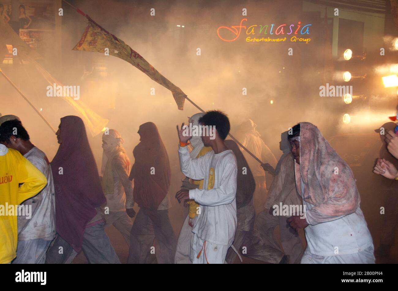 Thailand: Die Straßen von Phuket Town explodieren mit Feuerwerkskörpern, wenn die Parade vorbeizieht, Phuket Vegetarian Festival. Das Vegetarische Festival ist ein religiöses Festival, das jährlich auf der Insel Phuket im Süden Thailands stattfindet. Es zieht Massen von Zuschauern wegen vieler der ungewöhnlichen religiösen Rituale an, die durchgeführt werden. Viele religiöse Anhänger werden sich mit Schwertern niederschlagen, ihre Wangen mit scharfen Gegenständen durchbohren und andere schmerzhafte Handlungen begehen. Stockfoto