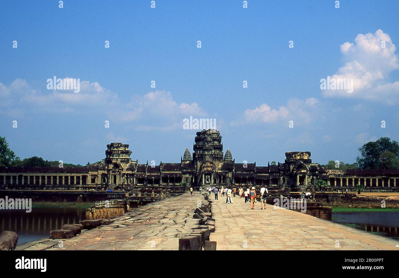 Kambodscha: Menschen auf dem Damm, der nach Angkor Wat führt. Angkor Wat wurde für König Suryavarman II. (Regierte 1113-50) im frühen 12. Jahrhundert als Staatstempel und Hauptstadt erbaut. Als besterhaltener Tempel am Standort Angkor ist er der einzige, der seit seiner Gründung ein bedeutendes religiöses Zentrum geblieben ist – zuerst Hindu, dem gott Vishnu gewidmet, dann Buddhist. Es ist das größte religiöse Gebäude der Welt. Der Tempel ist an der Spitze der hohen klassischen Stil der Khmer-Architektur. Es ist zu einem Symbol Kambodschas geworden, das auf seiner Nationalflagge erscheint. Stockfoto