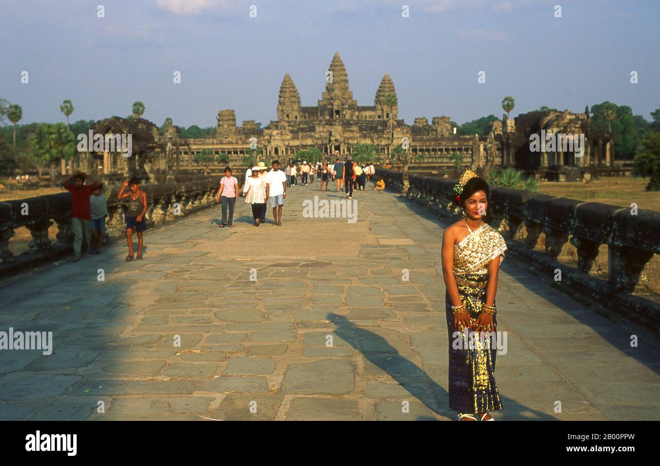 Kambodscha: Kambodschanische Braut auf dem westlichen Weg nach Angkor Wat. Angkor Wat wurde für König Suryavarman II. (Regierte 1113-50) im frühen 12. Jahrhundert als Staatstempel und Hauptstadt erbaut. Als besterhaltener Tempel am Standort Angkor ist er der einzige, der seit seiner Gründung ein bedeutendes religiöses Zentrum geblieben ist – zuerst Hindu, dem gott Vishnu gewidmet, dann Buddhist. Es ist das größte religiöse Gebäude der Welt. Der Tempel ist an der Spitze der hohen klassischen Stil der Khmer-Architektur. Es ist zu einem Symbol Kambodschas geworden, das auf seiner Nationalflagge erscheint. Stockfoto