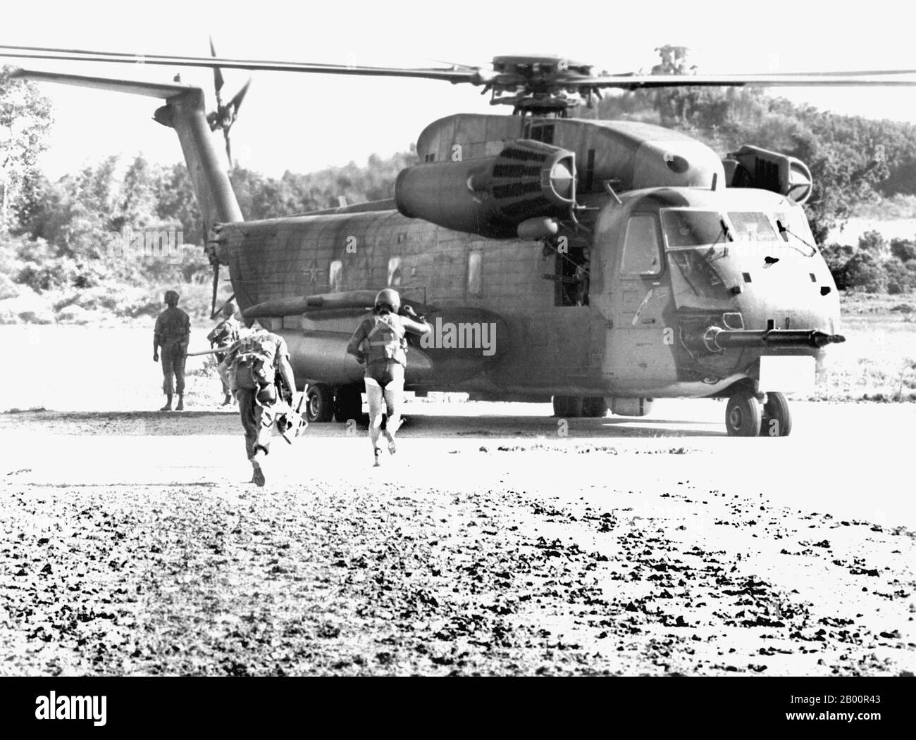 Kambodscha: Der Zwischenfall Von Mayaguez, 12.-15. Mai 1975. Ein USAF-Soldat des 40. Luft- und Raumfahrtgeschwaders führt Marines zu einem HH-53 Hubschrauber. Am 12. Mai 1975 beschlagnahmten die Roten Khmer die USS Mayaguez und ihre Besatzung in kambodschanischen Hoheitsgewässern, als sie sich auf dem Weg nach Thailand befanden. Die USA starteten zum ersten Mal eine Rettungsmission, die nach dem Absturz eines Hubschraubers in einer Katastrophe endete. Ein massiver Angriff wurde am 14-15. Mai gestartet und die Mehrheit der Besatzung wurde von der Insel Koh Tang gerettet, aber nicht bevor beide Seiten mehr als ein Dutzend Opfer verloren hatten. Stockfoto